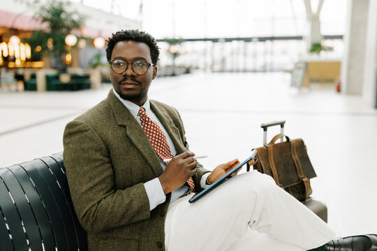 Business Professional Working on Tablet While Waiting at Airport