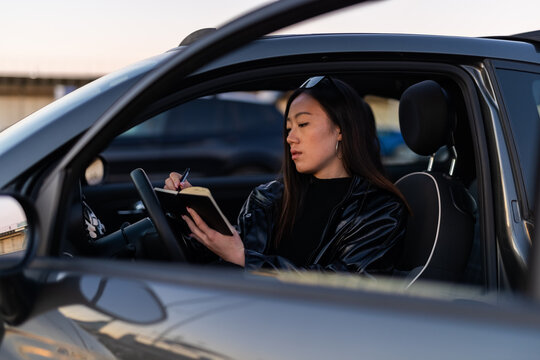 Woman writing diary in car
