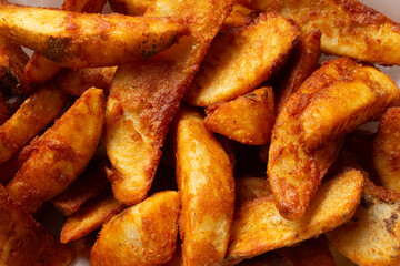 A top down view of a pile of potato wedges, as a background.