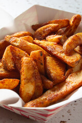 A closeup view of a tray of potato wedges.