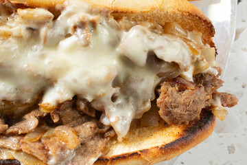 A top down view of a Philly cheesesteak sandwich.