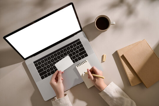 Someone working from home with a blank laptop screen, notepad