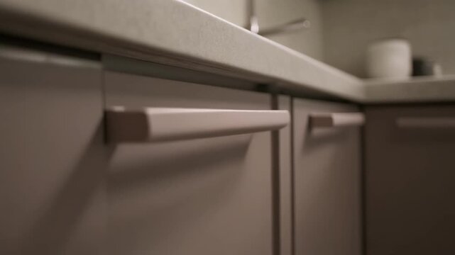 A closeup of kitchen cabinet handles and a countertop