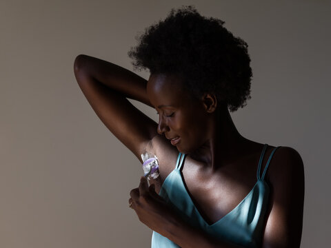Black woman shaving armpit with razor