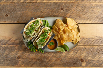 A top down view of two fish tacos and tortilla chips.
