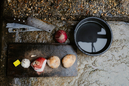 Chef preparing ingredients: potatoes, onion, garlic