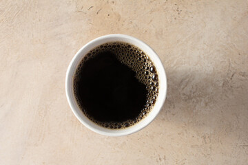 A top down view of a black coffee in a paper cup. © DAVID