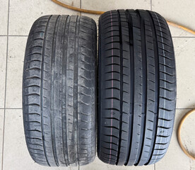 New and worn tires are displayed together, highlighting differences in tread patterns and wear
