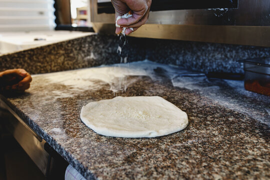 Pizza maker preparing Neapolitan pizza in the kitchen