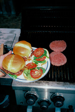 Grilling burgers on outdoors grill, shot on film 