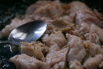 Cooked hake on a black cooking pan