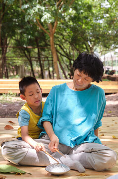 Chinese mother and son practice playing the hollow drum instrument 