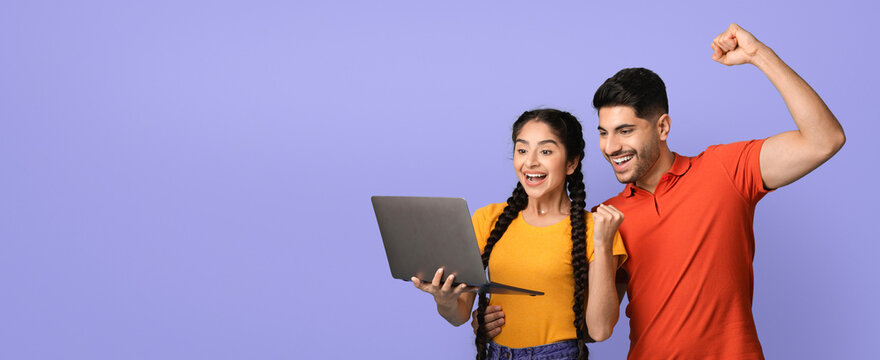 Two friends share a joyful moment as they look at a laptop screen together. Their expressions show excitement and happiness, set against a cheerful purple background.