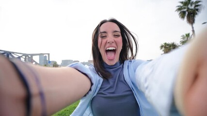 A joyful woman is smiling and laughing as she holds her arms out playfully, capturing a carefree moment filled with happiness and excitement. This image radiates positivity and fun.