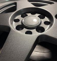 Close-up of a textured car wheel in a workshop, illuminated by daylight
