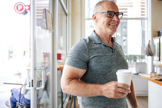 Smiling man with coffee cup indoors