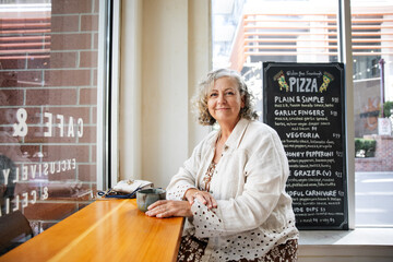 Smiling woman enjoying coffee in cafÃ©