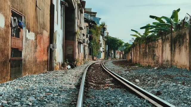 Nha Trang, Vietnam - 10.09.2025. A street with a train in Nha Trang, which runs between old residential buildings, almost at the very windows and doors. Railway tracks. Asia.4К	