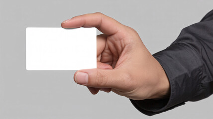 A hand holding a blank white card against a gray background with a black sleeve visible