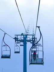 Chairlifts rise through thick winter fog on Jahorina Mountain, creating a serene alpine scene perfect for winter sports and travel concepts.