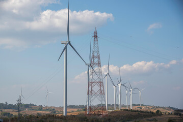 Powerful wind turbine farm for alternative energy production on bright orange sunset blue sky warm summer at highland. Cenerating clean renewable energy for sustainable development
