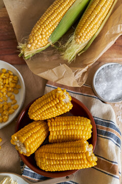 Fresh Corn on the Cob and Kernels With Salt Butter on a Rustic Table