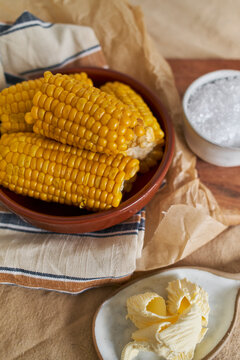 Fresh Corn on the Cob and Kernels With Salt Butter on a Rustic Table