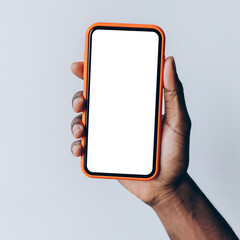 A person's hand holding a modern smartphone with a blank white screen, ideal for digital mockups and advertising