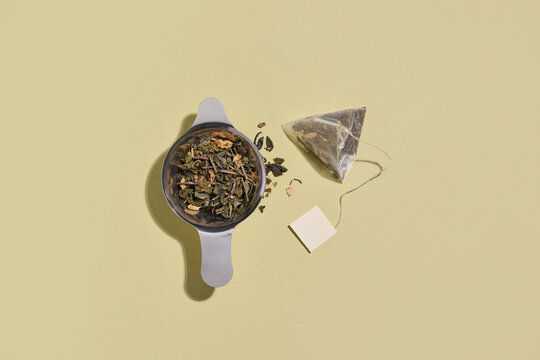 Loose leaf tea and pyramid tea bag on beige background