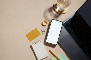 A modern minimalist workspace setup with a blank screen smartphone