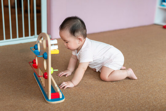 A sweet baby crawls toward a wooden toy, engaging with colors