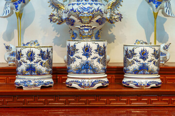 Traditional Asian Altar Setup with Ceramic Incense Burners and Sacred Crane Statues Background