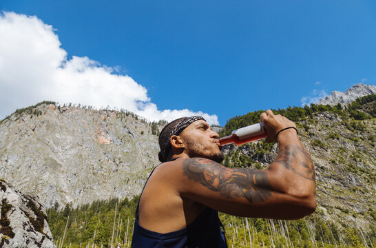 Adventurer Enjoying a Drink in a Scenic Mountain Location