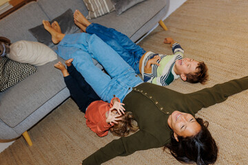 Mother and children playing happily on floor at home