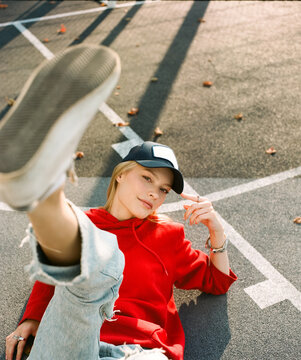 Woman in red hoodie lying on court with raised leg