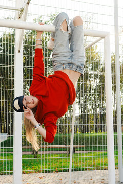 Playful woman hanging upside down on   football goals