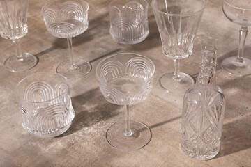 Antique crystal glasses and bottle displayed on rustic tabletop.