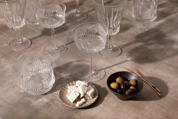 Antique glassware displayed with feta and olives.