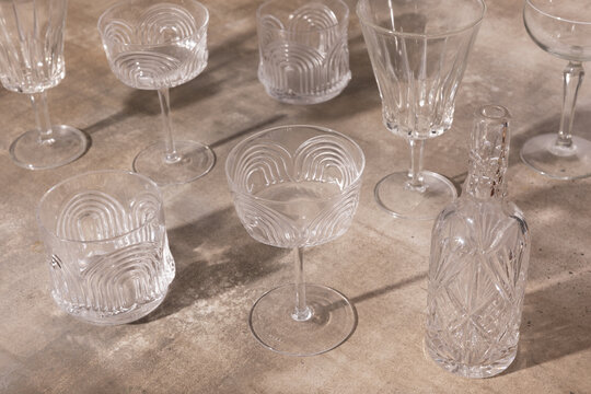 Antique crystal glasses and bottle displayed on rustic tabletop.