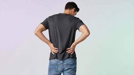A man, viewed from the back, clutches his lower back, expressing discomfort.