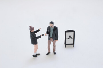 Fototapeta premium a Miniature Couple Interacting Outside Coffee Shop
