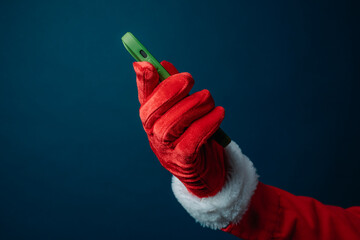 santa raising a green smartphone in red gloved hand