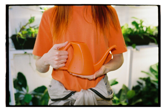 A woman holds a watering can for watering plants