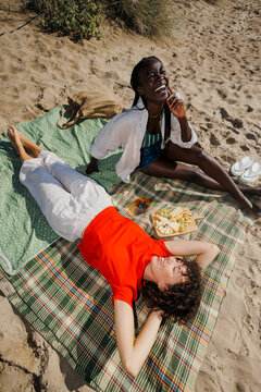 Diverse women friends enjoying summer beach picnic