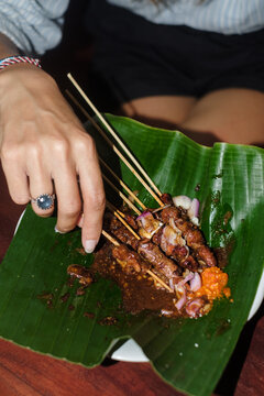 Delicious Skewers Served on Banana Leaf in a Vibrant Setting
