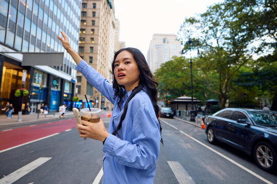 Woman waves for a cab in New York City