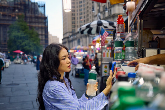 Woman buys a bottle of water in New York