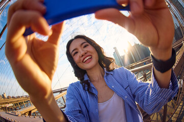 Woman captures selfies on a bridge