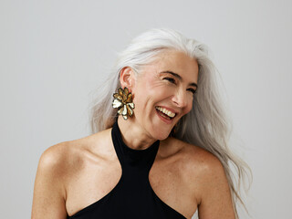 Elegant Woman With Gray Hair Smiling in Stylish Earrings
