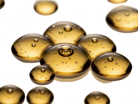 Closeup macro shot of golden amber liquid droplets with small internal bubbles isolated on transparent background